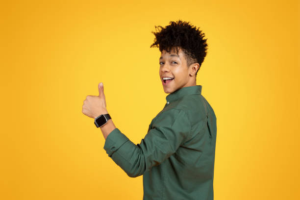 istock Positive african american guy looking over shoulder, showing thumb up 2153944133