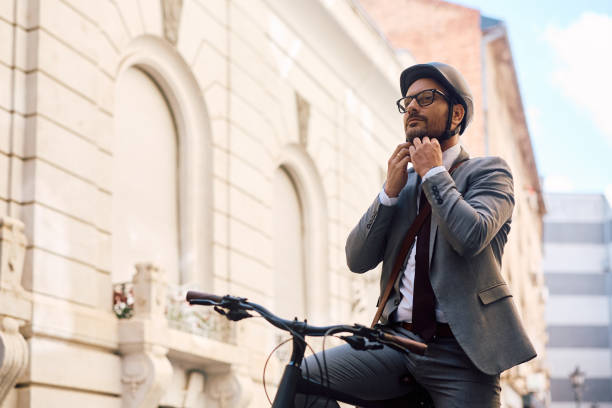 istock Businessman adjusting cycling helmet while going to work with a bicycle. 2153946314