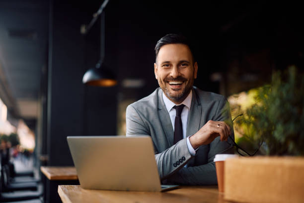 istock Happy entrepreneur working on computer in a cafe and looking at camera. 2153946582