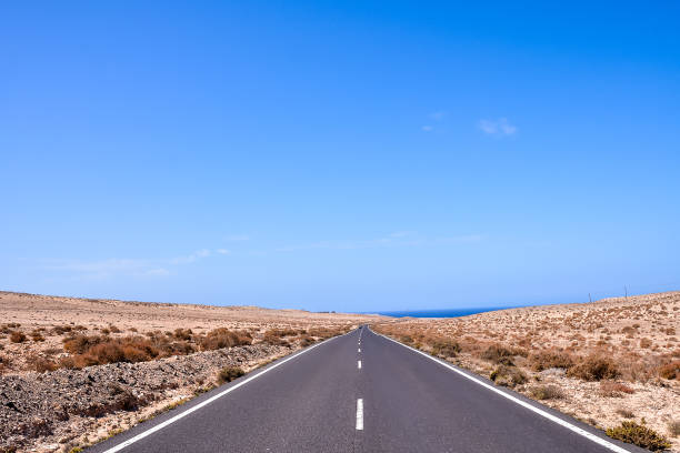 istock A long, empty road with a clear blue sky above 2153947978