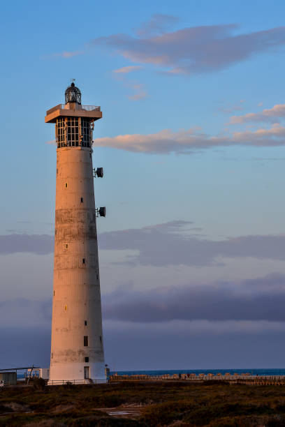 istock A lighthouse is standing on a beach with a cloudy sky in the background 2153948002