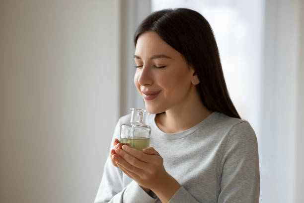 Woman holding a bottle of essential oil while testing it
