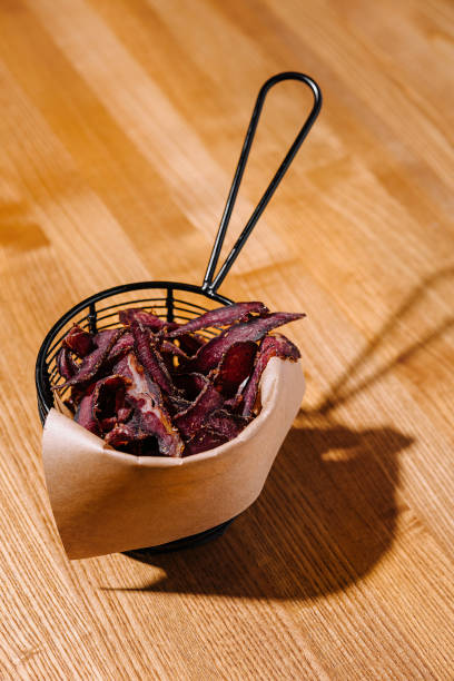 istock Crispy beef chips in basket on wooden table 2153951084