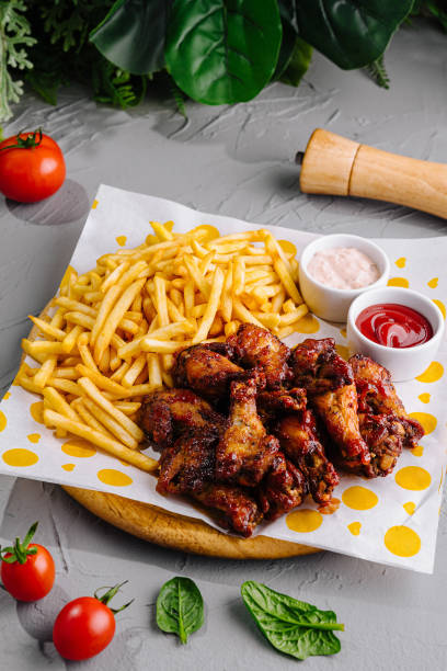istock Crispy chicken wings and fries with dips on table 2153952193