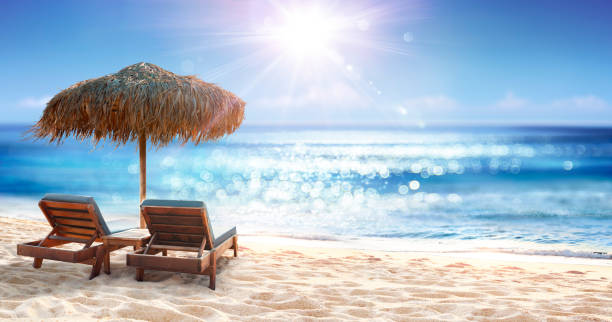 istock Chairs And Parasol In Beach With Glittering On Ocean 2153952417