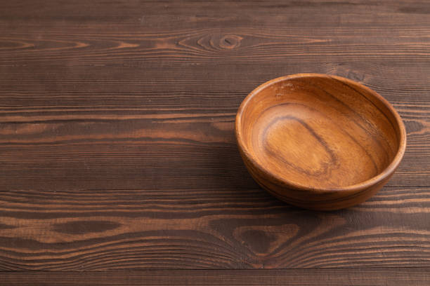 istock Empty brown wooden bowl on brown wooden. Side view, copy space 2153956709