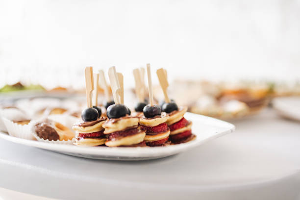 Finger food - Mini pancakes with blueberries, strawberries and raspberries. Party food