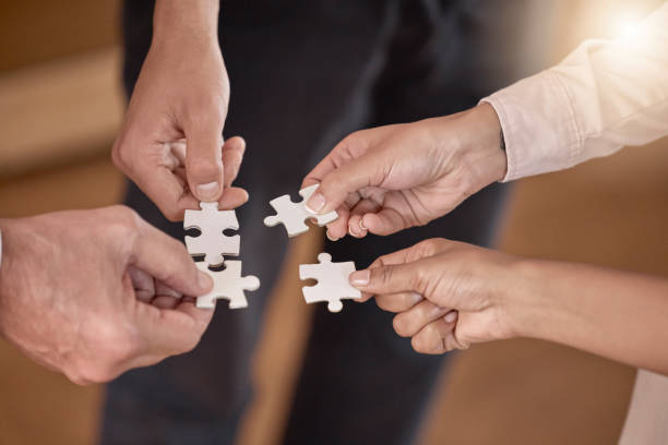 istock Business people, hands and puzzle piece in planning, collaboration or teamwork brainstorming at the office. Hand of group in team building, strategy or activity for engagement, support or interaction 2153959413