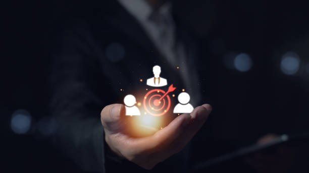 istock Customer relationship management concepts Businessman holds target icon linked to human icon for customer target group. Improving information exchange and customer service 2153960492