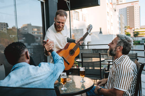 istock Group of friends drinking beer and playing guitar 2153961909