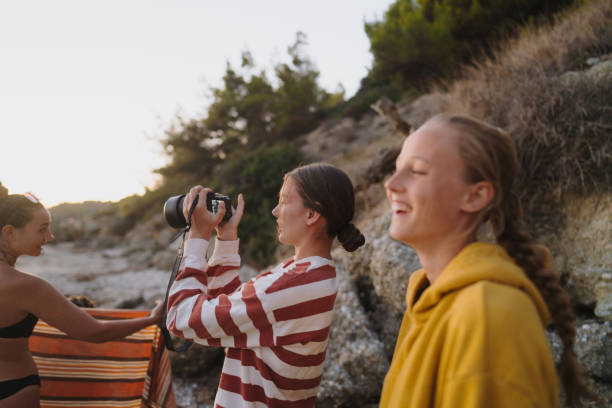 istock Young woman photographing her friends while on a spring break! 2153964232
