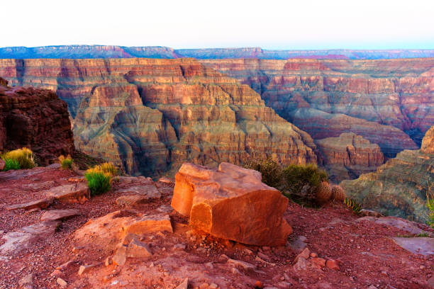 Panoramic view of the Grand Canyon in warm hues of the setting sun showcasing countless layers that tell a story of the geological history.