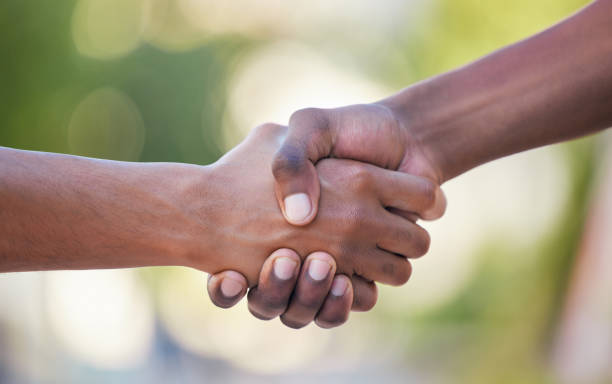 istock Hands, handshake and friendship in trust, support or care for relationship, agreement or unity against bokeh background. Hand of people shaking for community, collaboration or partnership deal 2153967129