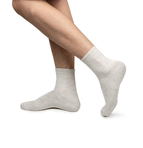 istock Male feet wearing grey cotton socks on white background 2153967191