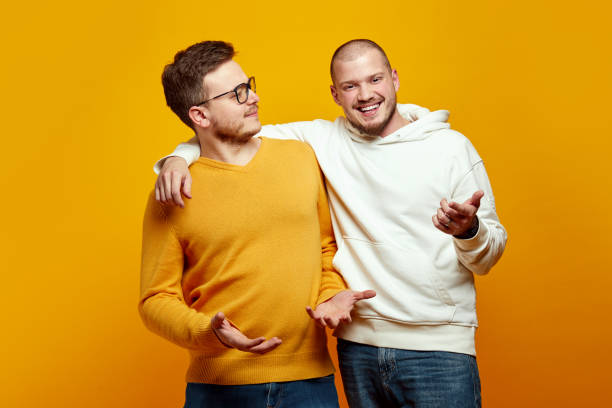 istock Two young men embracing each other, One guy looking with uncertainty, second male giving solution 2153967759