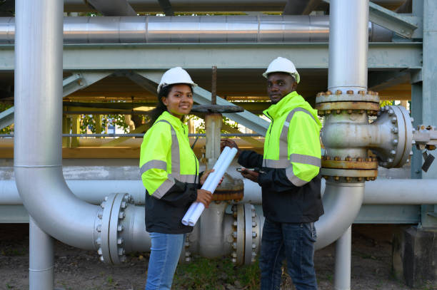 istock Male and female engineers check the drawing system inspection with the real pipe system of the new construction project, engine engineer, Sysetm cooling machine, compared to drawing design. 2153968393