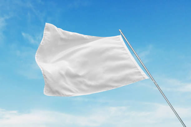 istock A white flag flutters in the wind with clean texture, perfect for state or advertising flag mockup, set against a clear blue sky 2153968964