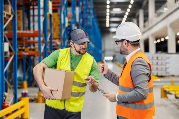 istock A warehouseman is holding box and talking with his superior about shipping and logistic. 2153968984