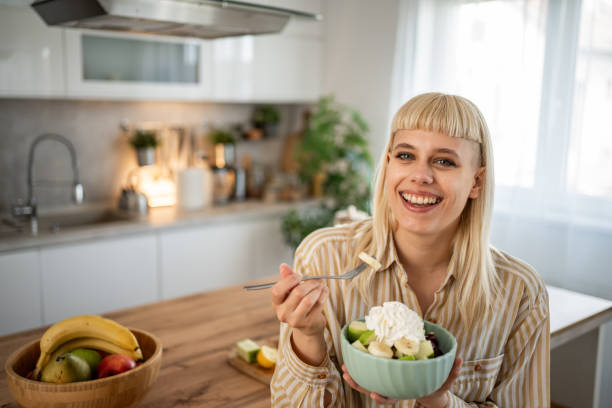 istock A young woman is eating a fruit salad 2153969185