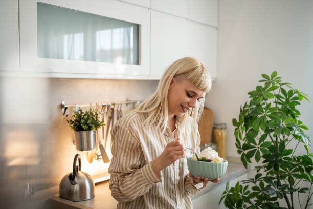 istock A young woman is eating a fruit salad 2153969224