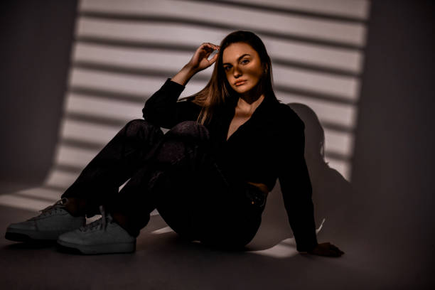 istock Cute Female Sitting On The Ground While Hiding Behind Window Blinder Shades 2153972980