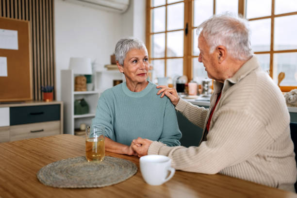 istock Senior couple talking while having coffee and apple juice in a domestic kitchen 2153974958