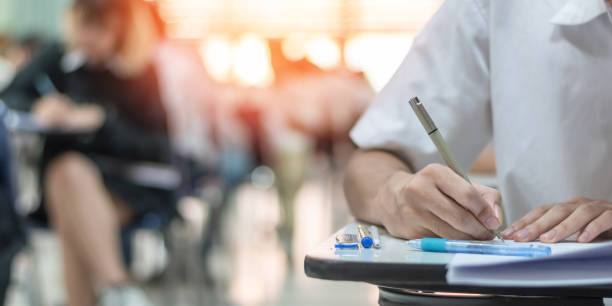 istock Exam at school with student's taking educational admission test in class, thinking hard, writing answer in university classroom, education and world literacy day concept 2153977365