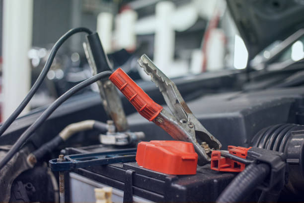 istock Close-up of a charging car battery with electricity using connecting cables, battery inspection. Selective focus. Blurred background. 2153978812