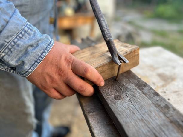 istock The hand that was holding a hammer to pull nail out. 2153980367