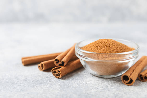 istock Cinnamon powder on background. Spicy spice for baking, desserts and drinks. Fragrant ground cinnamon. Cinnamon stick. Place for text. Copy space. 2153980418