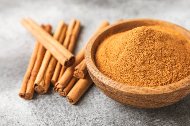 istock Cinnamon powder on background. Spicy spice for baking, desserts and drinks. Fragrant ground cinnamon. Cinnamon stick. Place for text. Copy space. 2153980449