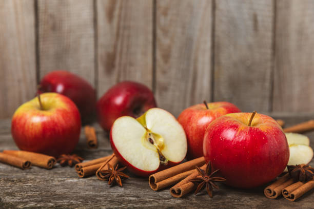 istock Apples with cinnamon on a textured wooden background. Fragrant red spiced apples with cinnamon sticks and star anise. Apple slices with spicy spices. Place for text. Copy space. Harvesting. Fruits. 2153981344