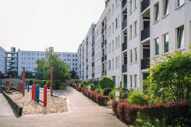 Contemporary apartment buildings in Berlin, Germany, featuring a well-maintained green courtyard and blue sky. Urban living and modern architecture.