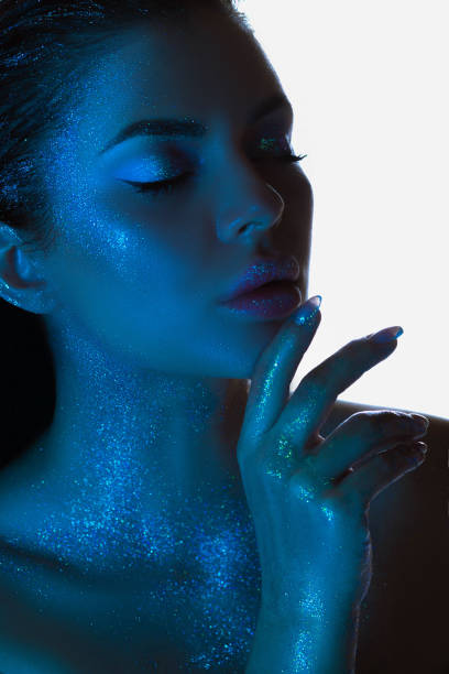 istock Woman with blue powder on her face, creating a vibrant and striking appearance 2153983604