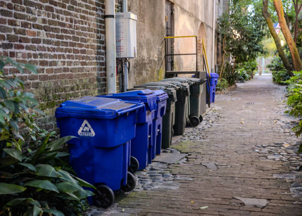 Charleston, South Carolina - May 6, 2024:  Philadelphia Alley in Charleston is a popular spot for tourists, shown here with recycling and garbage bins neatly lined up along the side of the alley in a late afternoon.  HDR encoded.