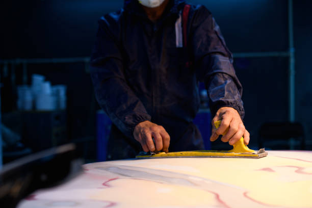 istock Partial shot of workman in protective suit buffing car part in service station 2153985397