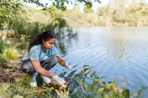 istock Woman Collects Water Sample for Environmental Conservation 2153986897