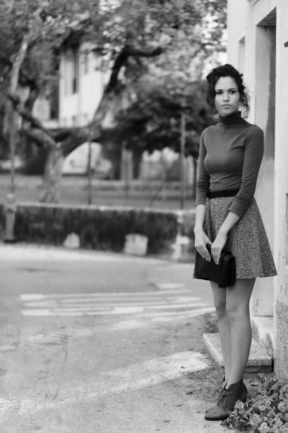 istock Woman stands waiting, holding clutch, blurred background 2153988862
