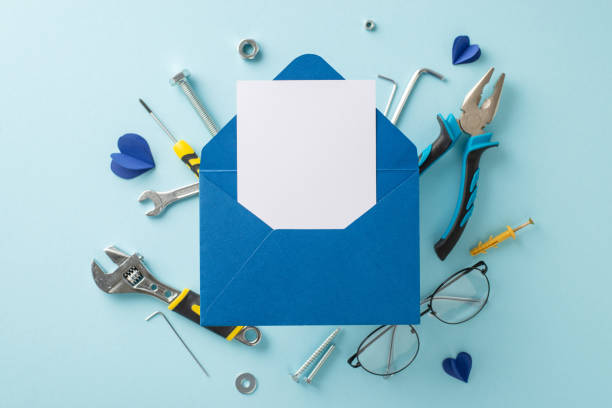 istock A creative arrangement featuring a blue envelope and greeting card surrounded by various tools on a light blue background, symbolizing Father's Day 2153989084