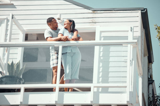 istock Loving young mixed race couple in pyjamas sharing romantic moment while being affectionate and looking into each others eyes on the balcony of their new home or while on holiday enjoying their honeymoon 2153989770