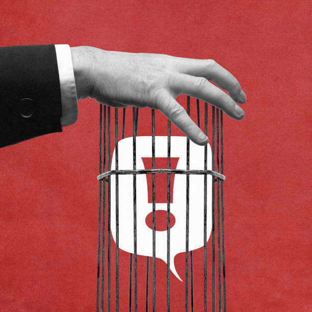 Freedom of Speech Under Lock. Speech bubble closed in birdcage, held by hand dressed in formal suit. Control of truth. Contemporary art collage.
