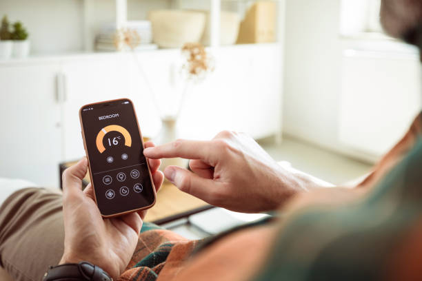 istock Man using mobile phone to control termostat at home 2153991218