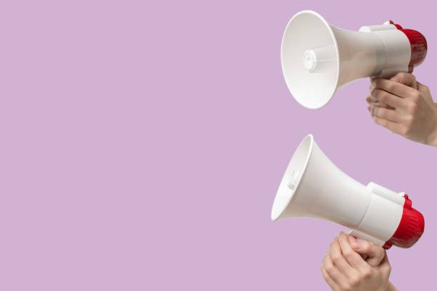 istock Megaphone in woman hands on a lilac background. 2153992357