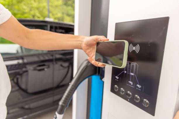 istock Woman Using Mobile Phone to Pay at Charging Station 2153994338