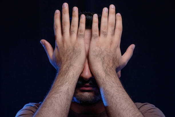 Man Covering Face with Hands in Despair