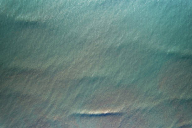 Texture of green transparent ocean water above top drone view