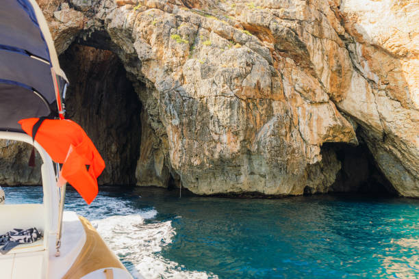 View from sailing boat of beautiful cave shapes and crystal blue Ionian Sea in Puglia, South Italy