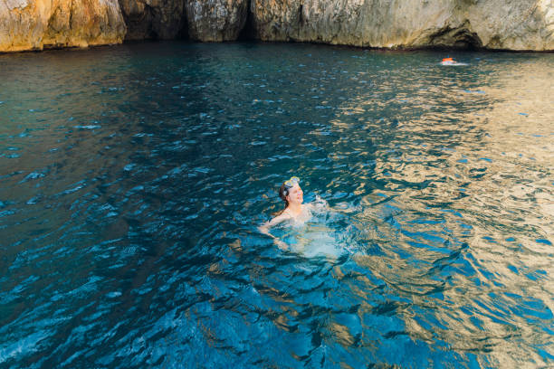 istock Happy Woman Snorkelling Inside Cave With Crystal Blue Water 2153998483