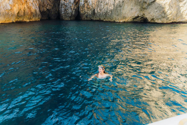 istock Happy Woman Snorkelling Inside Cave With Crystal Blue Water 2153999101