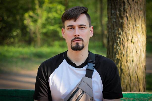 A guy poses outdoors in a park. Summer days, summer mood. High quality photo